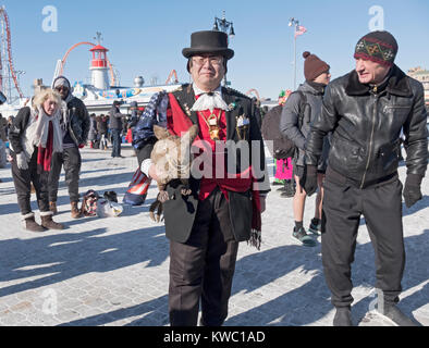 Eine asiatische amerikanische Mann mit einem ausgestopften Kaninchen auf dem Boardwalk am Tag die 114 Polar Bear Club Das neue Jahr schwimmen. Stockfoto