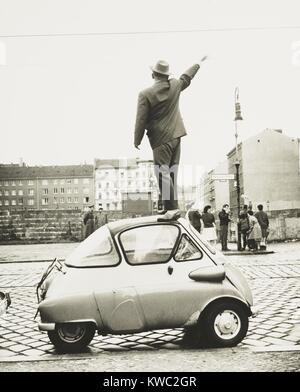 Ein Mann stand auf einem kleinen dreirädrigen Auto winkend auf die neu errichtete Berliner Mauer. Diese West Berliner Wellen zu Ostberliner an Sept. 8, 1961 In der Bernauer Straße, die parallel zur Wand verläuft. (BSLOC 2015 2 263) Stockfoto