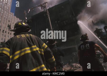 Feuerwehrmann im World Trade Center Site im folgenden September 11. Terroranschlag. Das Bachwasser soll noch stehenden WTC 6. Auf der linken Seite ist das New York Telefon Firma Gebäude, beschädigt aber reparierbar. (BSLOC 2015 2 56) Stockfoto