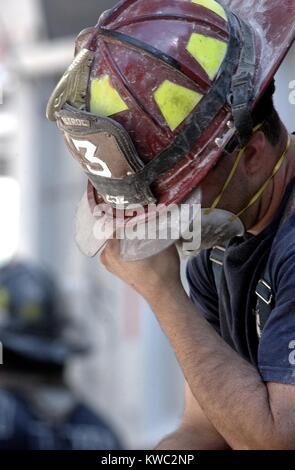 NYC Feuerwehrmann eine Auszeit nimmt während der rettungsarbeiten auf Sept. 14, 2001. Nur 13 Menschen wurden von gerettet lebendig aus den Trümmern, und die Waren innerhalb der ersten 24 Stunden gefunden. New York City, nach dem 11. September 2001 Terroranschläge. Us Navy Foto von Jim Watson (BSLOC 2015 2 77) Stockfoto