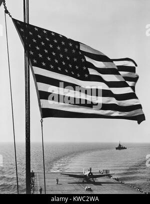 Flagge der Vereinigten Staaten rastet in der Brise über die USS Santee. November 1942. USS Santee war einer von 4 escort Carrier in Operation Torch, Nov. 1942 Invasion der Alliierten in Nordafrika. Foto von Horace Bristol, Mitglied des U.S. Naval Aviation fotografischen unter dem Kommando von Kapitän Edward Steichen. Weltkrieg 2. (BSLOC 2015 13 119) Stockfoto