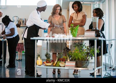 First Lady Michelle Obama und Valerie Trierweiler, französischer Journalist und Autor. Sie beobachten, wie ein Student kochvorführung am Gary Comer Youth Center in Chicago, Illinois, 20. Mai 2012. Valerie Trierweiler war der Partner von Präsident François Hollande von Frankreich. (BSLOC 2015 13 204) Stockfoto