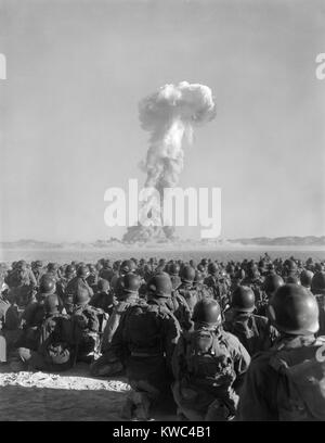 Übung-Desert Rock, 1. November 1951. Männer der US-Armee 11. Luftlandedivision, Uhr eine Wolke von radioaktiven Rauch Aufstieg in Yucca Flats. Soldaten durchgeführten Manöver Begrenzung der Strahlung Dosis-Grenzwert wurde bei 3.0 Rem festgelegt. Jedoch erhielt 68 Soldaten überschüssige Forderungen von über 3 bis 10 Rem (Roentgen gleichwertige Mann). Eine Rem bringt mit sich eine 0,055 % Chance schließlich Krebs zu erkranken. (BSLOC 2015 2 14) Stockfoto