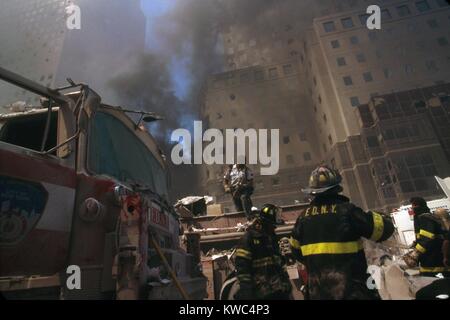 Feuerwehr inmitten der Trümmer nach dem 11. September Terroranschlag auf World Trade Center. Im Hintergrund sind beschädigte Gebäude des World Financial Center, New York City, 11. September 2001. (BSLOC 2015 2 44) Stockfoto