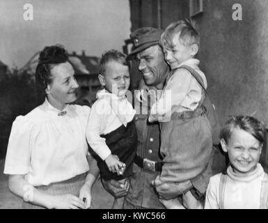 Entladen Deutscher Soldat Fritz Reidel zurück zu seiner Frau und seinen Kindern, 21. Mai 1945. Us-Militär begann Entladen deutsche Soldaten nach medizinischen Prüfungen und die Abnahme von Fingerabdrücken. Sie erhielten 40 Mark, Entlastung Papiere und Transport in ihre Häuser. Reidel, war der erste Kriegsgefangenen aus dem Kriegsgefangenenlager in Plauen, Deutschland. Weltkrieg 2 (BSLOC 2015 13 78) Stockfoto