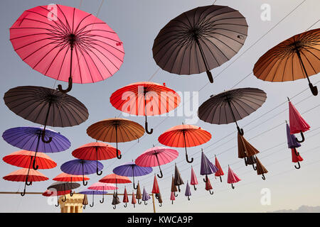Sammlung von bunten Sonnenschirmen bis in einer offenen Position über eine Straße mit Schatten, Yazd, Iran hängen. Stockfoto