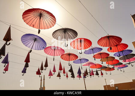Viele bunte Schirme hängen über der Stadt vor dem Hintergrund des Himmels als Dekoration, die Stadt Yazd im Iran. Stockfoto