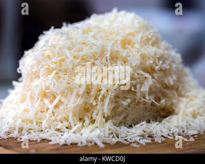Geriebenen Parmesan auf einem Holzbrett in Nahaufnahme Stockfoto