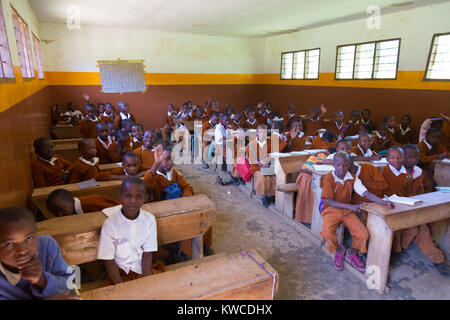 Kinder in Uniformen in der Grundschule Klassenzimmer listetning zu Lehrer in ländlicher Umgebung in der Nähe von Arusha, Tansania, Afrika. Stockfoto