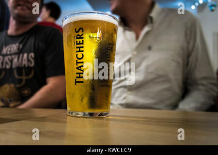 Ein pint Glas Thatchers Apfelwein auf einem Tisch in einer Bar. Stockfoto