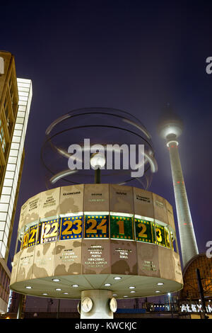 Die berühmte Weltzeituhr und der Fernsehturm am Alexanderplatz in Berlin in der Nacht. Stockfoto