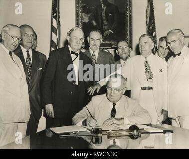 Präsident Harry Truman unterzeichnet die Atlantischen Pakt am 27. Juli 1949. Hinter Truman, stehend, L-R: Sen Walter George; Def. Sec. Louis Johnson; Sen. Tom Connally; Sek., Dean Acheson; VP Alben Barkley; Sen. Arthur Vandenberg. - (BSLOC 2014 15 72) Stockfoto