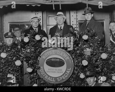 Knute Rockne stehen auf der Rückseite des Waggon verziert mit Blumen, 1930. Rockne ist flankiert von Trainer Frank Cariedo und Fußball Spieler Tom Conley für Kalifornien verlassen. -(BSLOC 2015 1 118) Stockfoto