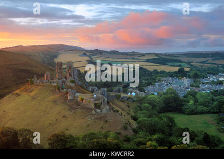 CORFE CASTLE, Dorset, England: die Ruinen von Corfe Castle und das Dorf bei Sonnenaufgang Stockfoto