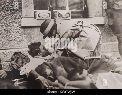 Das amerikanische rote Kreuz Krankenschwester Hilfe für verwundete Soldaten in Montmirail, Frankreich, 31. Mai 1918. Sie hilft ein Soldat aus einer Tasse trinken, wie er liegt auf einer Eisenbahn Plattform warten auf die Evakuierung (BSLOC 2017 1 15) Stockfoto