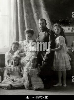 Nicholas II und Familie bei der Taufe von Czarevich Alexei, 1904. Im Uhrzeigersinn von Zar Nicolas sind Großfürstinnen Olga, Anastasia, Maria, Tatiana, Zarin Alix von Hessen mit ihrem Sohn (BSLOC 2017 2 2 8) Stockfoto