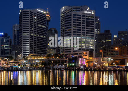 Cockle Bay Wharf in Darling Harbour bei Nacht, mit Sydney Central Business District im Hintergrund - Sydney, New South Wales, Australien Stockfoto