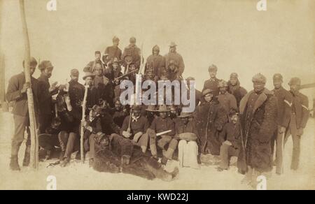 Buffalo Soldaten des 25 Infanterie, mehrere tragen Buffalo Roben, Ft. Keogh, Montana, 1890. Auf der linken Seite, zwei Männer zu erreichen, für eine Flasche weitergeleitet werden, während Sie für Dies stellte entspannt Gruppenporträt (BSLOC 2017 20 104) Stockfoto