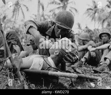 US Navy corpsman gibt einen Drink zu verletzte Marine auf Guam, Juli 1944, während des Zweiten Weltkrieges 2. (BSLOC 2017 20 187) Stockfoto