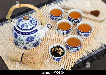 Japanische Jasmin Tee Zeremonie mit Teekanne, Tassen, Blätter, Schneebesen, Bürste und Schaufel auf Bambus. Auch in der Kräutermedizin verwendet. Stockfoto