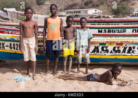 Gruppe von Jugendlichen neben Fischerboote am Strand in Dakar, Senegal Stockfoto