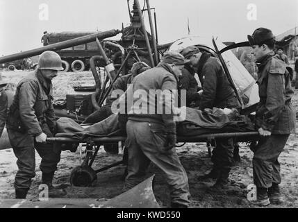 Ärzte tragen eine verletzte US-Soldat von einem Rettungshubschrauber. Sein nächster Halt die mobile der Chirurgischen Klinik zu einem fünften Luftwaffe fighter Streifen werden nur eine kurze Entfernung von der Schlacht Linien koreanischen Krieges, 1950-1953. (BSLOC 2014 11 193) Stockfoto