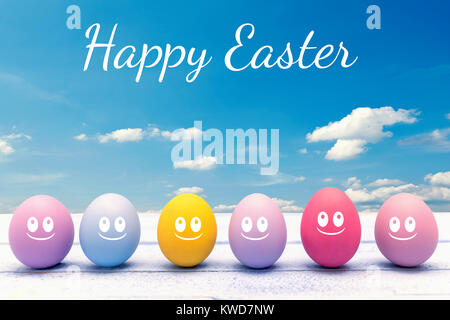 Bunte Ostereier auf einem Holzbrett mit der Frohe Ostern Schrift Stockfoto