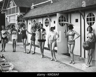 Die französischen Frauen stellen in den neuesten modischen Badeanzügen außerhalb ihrer Cabanas am Strand in Dieppe. Ca. 1925. (BSLOC 2015 17 203) Stockfoto