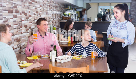 Ziemlich gastfreundlich Kellnerin Besucher helfen mit Menü, um im Cafe Stockfoto