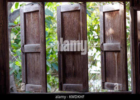 Ein geöffnetes Fenster in einem alten Holzhaus am frühen Morgen in Thailand Stockfoto