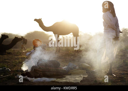 Szene in Pushkar Camel Fair, Senior Händler von Kamin in der Herde Kamele, Pushkar, Rajasthan, Indien Stockfoto