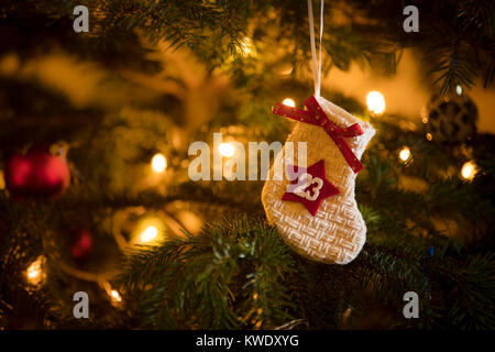 Traditionelle Adventskalender Strumpf mit dem Datum des 23. Dezember hängen an einem traditionellen Weihnachtsbaum. Stockfoto