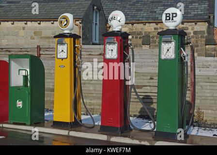Drei farbenfrohe vintage Benzin pumpen auf eine Garage im Black Country Living Museum, Dudley, West Midlands, UK Stockfoto