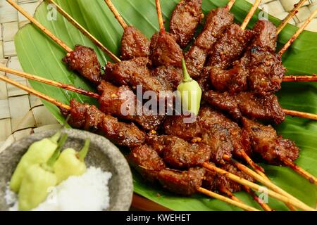 Sate Babi Bali. Balinesische pikant Schwein satay, serviert mit Gewürz von Meersalz und frische grüne Chilischoten. Stockfoto