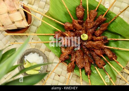 Sate Babi Bali. Balinesische pikant Schwein satay, serviert mit Gewürz von Meersalz und frische grüne Chilischoten. Stockfoto