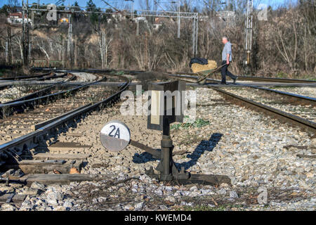 TOPCIDER, Belgrad, Serbien - Manuelle Rail Track Switch vor einem Mann drücken Schubkarre auf ein fußgängerüberweg Stockfoto