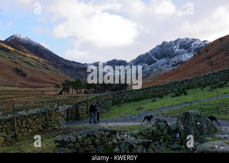 Ein paar Wanderer mit Ihrem Hund vorbei Warnscale unten in der Nähe von Heuballen Berg im englischen Lake District Stockfoto