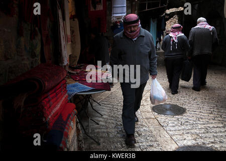 Hebron, Palästina, 8. Januar 2011: der Mann, der in kuffiyas Kopfbedeckung zu Fuß in einem ALEE in der Altstadt von Hebron. Stockfoto