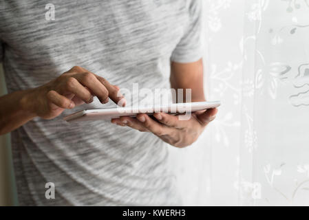 Asian teen Buzy mit seinem Tablet. Soziale lifestyle Konzept Stockfoto