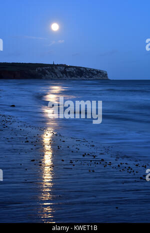 Ein super Mond über das Downs in Culver auf der Isle of Wight mit Sandown Bay Strand und Wellen im Vordergrund. Atmosphärische Mondaufgang über Meer. Stockfoto