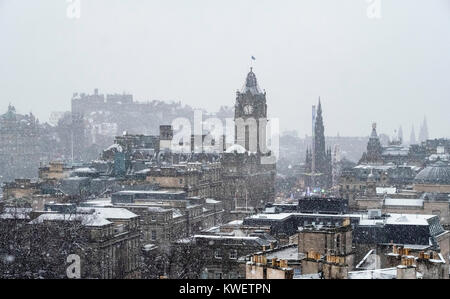 Schnee fällt auf die Stadt Edinburgh im Dezember. Blick auf die Skyline der Stadt vom Calton Hill, Schottland, Großbritannien. Stockfoto