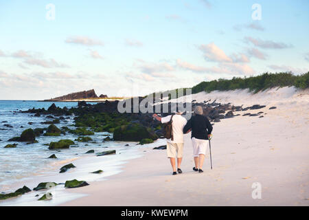 Ein älteres Ehepaar zu Fuß am Strand, Espanola Island, Galapagos Inseln Ecuador Südamerika - Beispiel für Senioren reisen Stockfoto