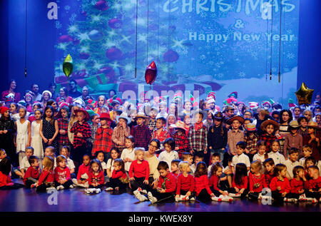 Alle Kinder der Schule auf der Bühne an ihren Weihnachtskonzert singen Stockfoto