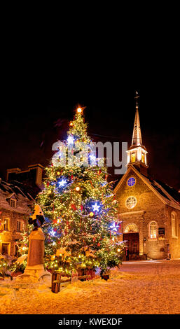 Weihnachten Dekorationen und frischen Schnee in Petit Champlain Bereich von Quebec City bei Nacht - in Place Royale mit der Kirche Eglise Notre Dame des Victoires Stockfoto