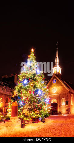 Weihnachten Dekorationen und frischen Schnee in Petit Champlain Bereich von Quebec City bei Nacht - in Place Royale mit der Kirche Eglise Notre Dame des Victoires Stockfoto