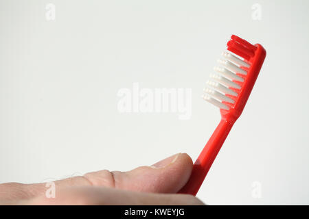 Rot Zahnbürste in der Hand konzeptionelle Bild, die Förderung einer gesunden Lebensweise. Kopieren Sie Platz. Stockfoto