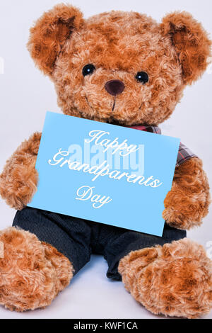 Cute teddy bear Holding ein blaues Schild, das liest gerne Großeltern-Tag auf weißem Hintergrund Stockfoto