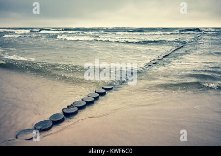 Retro getonten Bild einer alten hölzernen Strand Wellenbrecher, ruhige natürliche Hintergrund. Stockfoto