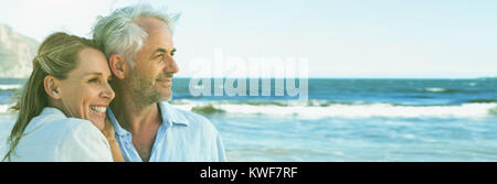 Glückliches Paar umarmt am Strand, Blick auf das Meer Stockfoto