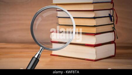 3D-Vergrößerungsglas über Büchern Stockfoto